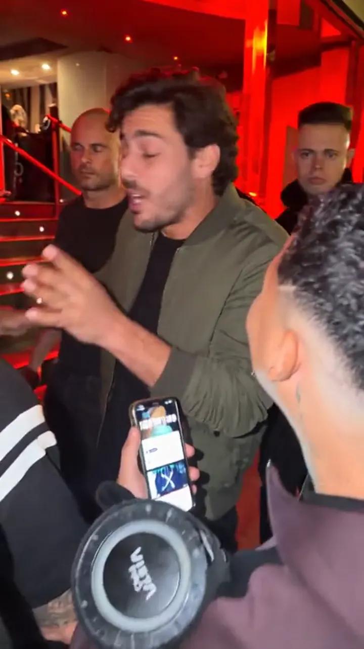 Un cuadro posterior de un video terminado: una persona generada con IA en pleno verso con el mismo público y cámara del clip original